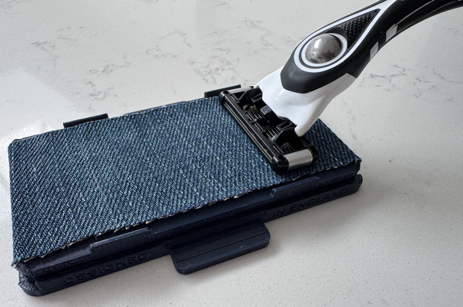 Razor cartridge resting on the Razor Geeks Razor Maintainer's recycled denim stropping strip